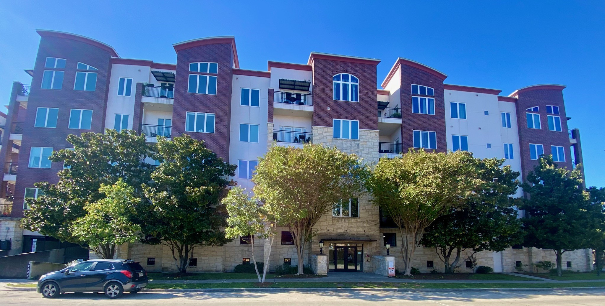 a front view of a building with trees