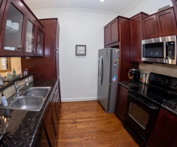 a kitchen with wooden cabinets a sink a stove a refrigerator and microwave