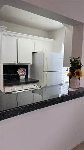 a kitchen with a refrigerator and a sink