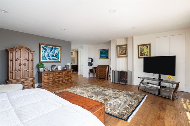 a living room with a large window and a dresser