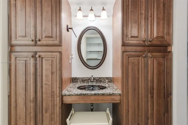 a bathroom with a granite countertop sink a mirror and a shower