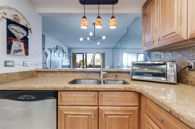 a kitchen with kitchen island granite countertop a sink stainless steel appliances and cabinets