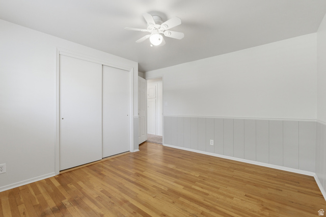 148 Tennyson Avenue Sandy, UT 84070 - Photo 25 of 55 Room featuring wood-finish flooring, a ceiling fan with integrated lighting, and a partial panel wall treatment