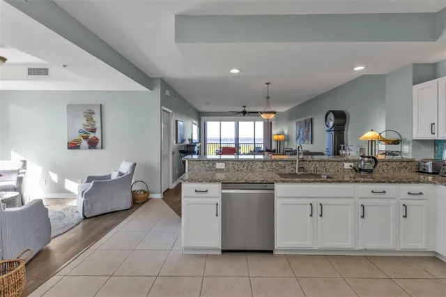 a kitchen with granite countertop a sink and white cabinets