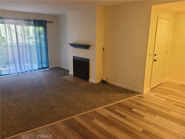 an empty room with wooden floor ceiling fan