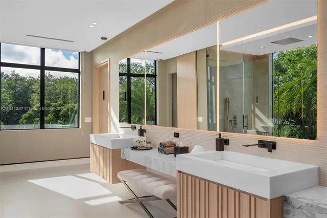 a large bathroom with a double vanity sink a large mirror and a bathtub