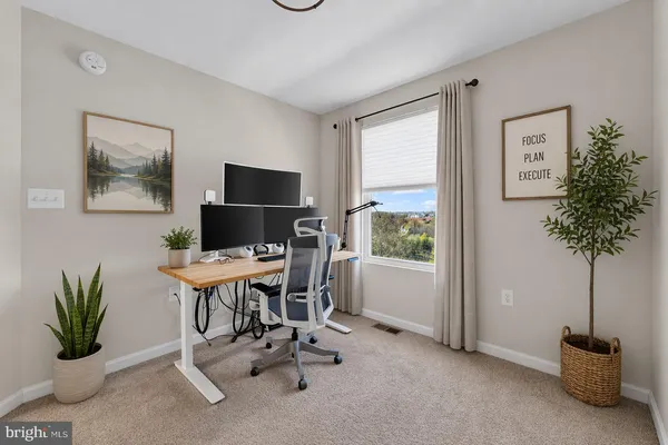 a view of a workspace with furniture and a potted plant