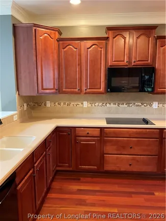 a kitchen with granite countertop a refrigerator and cabinets