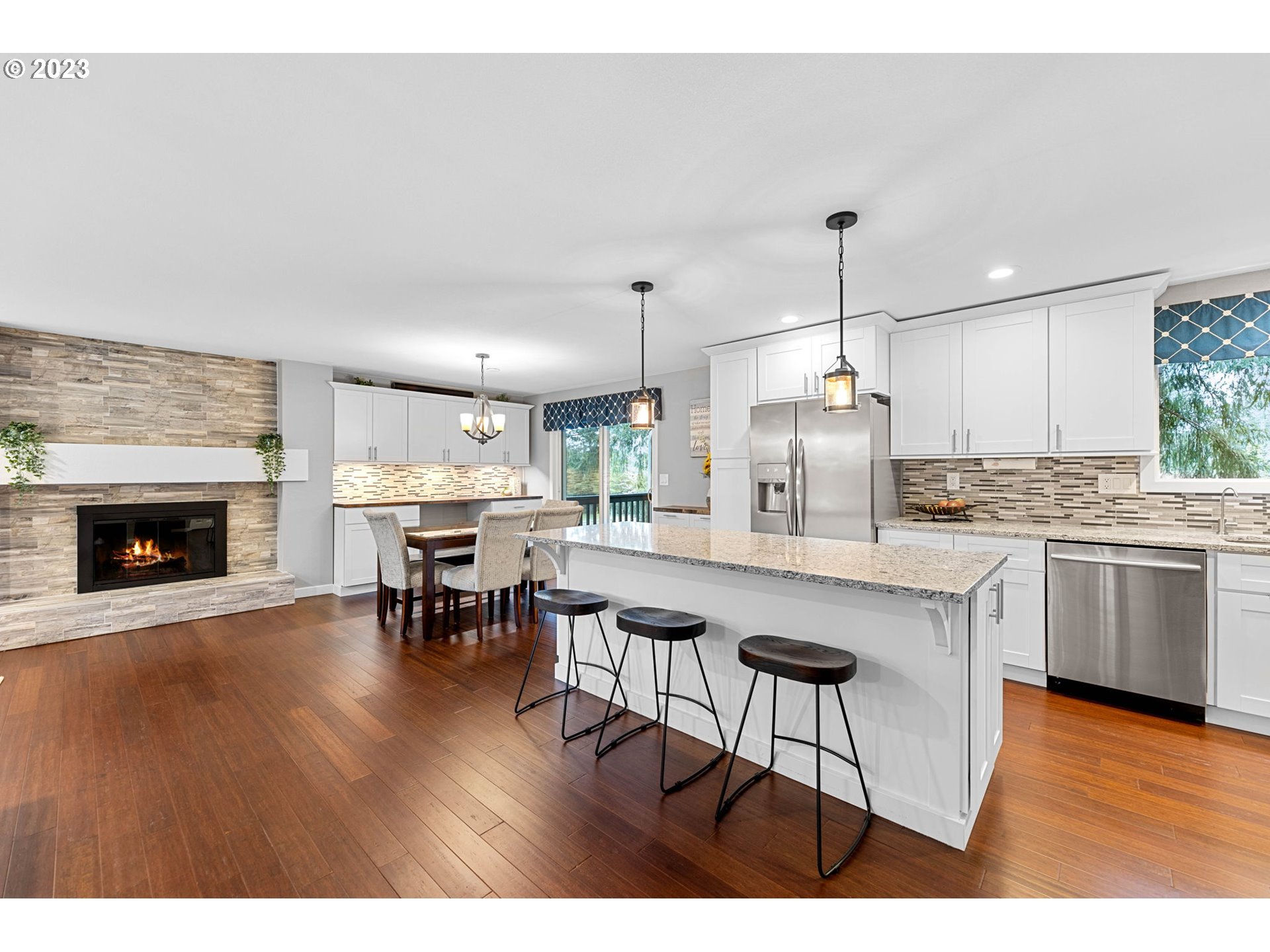 4412 Northeast 292nd Avenue Camas, WA 98607 - Photo 11 of 48 a open kitchen with granite countertop a stove a sink a dining table and chairs with wooden floor