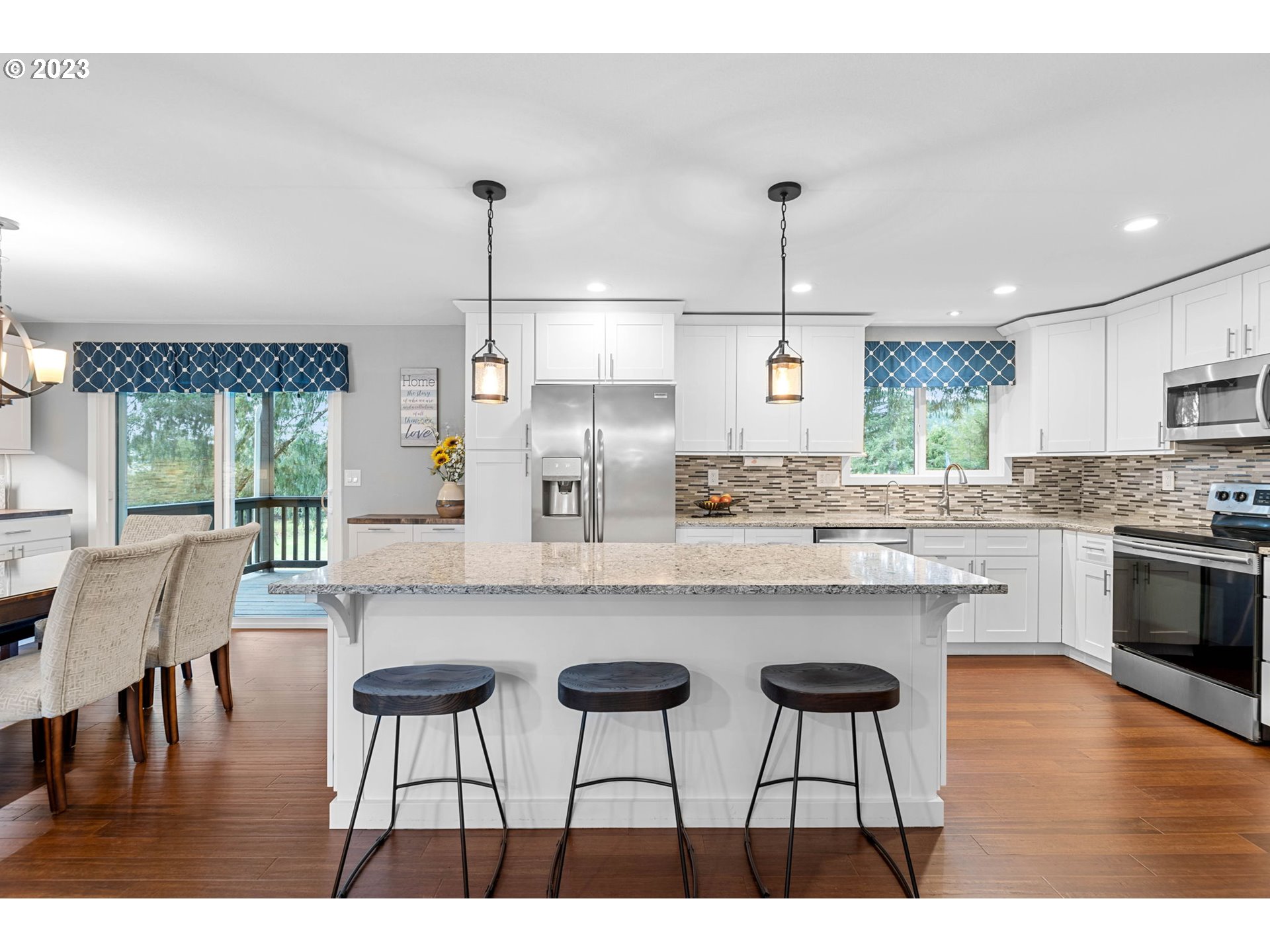 4412 Northeast 292nd Avenue Camas, WA 98607 - Photo 7 of 48 a kitchen with kitchen island granite countertop a dining table chairs and white cabinets