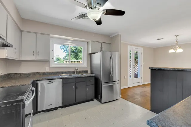 a kitchen with stainless steel appliances granite countertop a refrigerator a stove a sink and a refrigerator