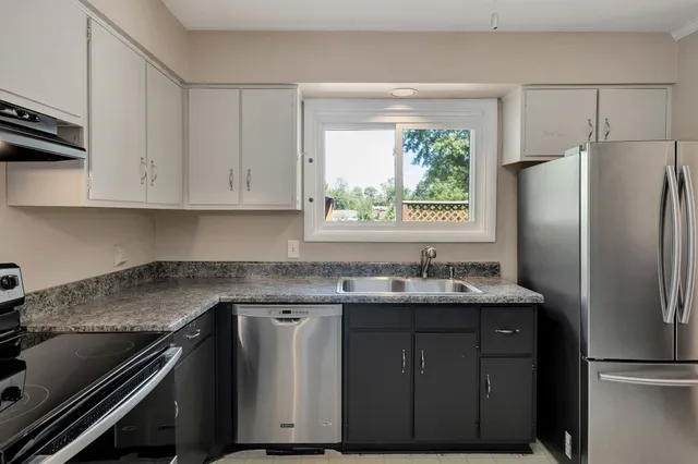 a kitchen with stainless steel appliances granite countertop a sink stove and refrigerator