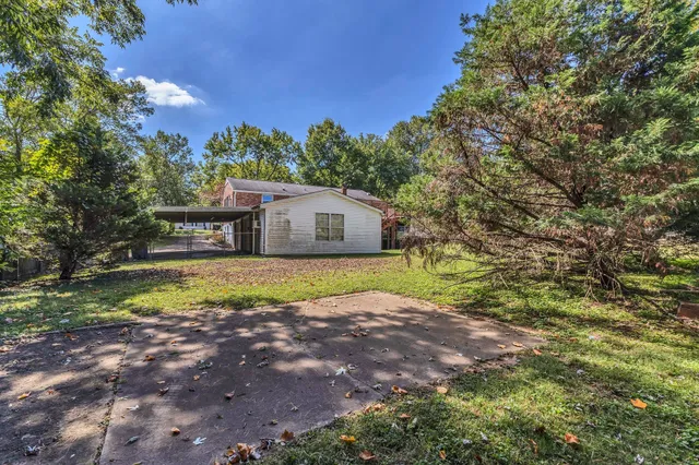 a backyard of a house with table and chairs