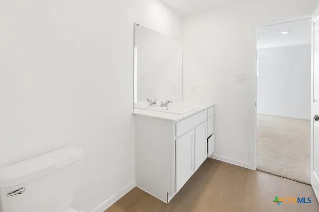 a view of a hallway with white cabinets