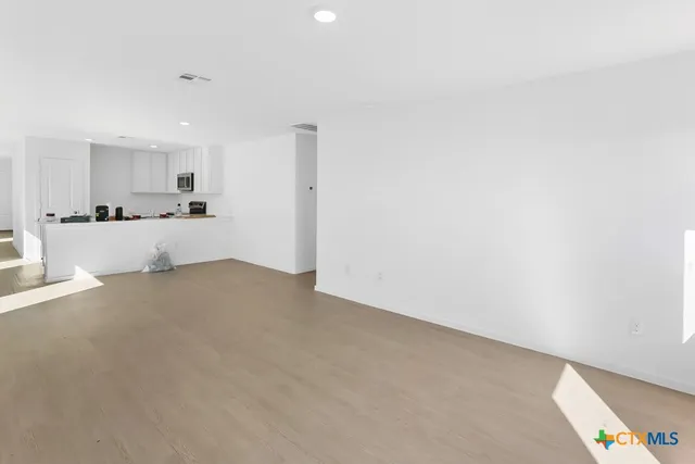 a large white room with kitchen island and a refrigerator