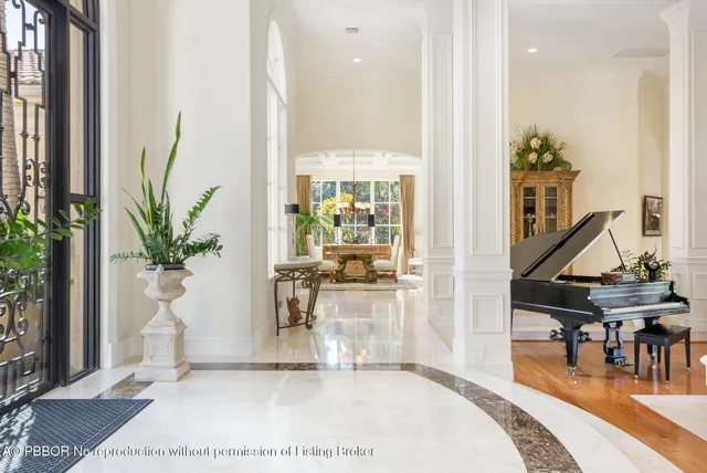 a living room with furniture a piano and a potted plant