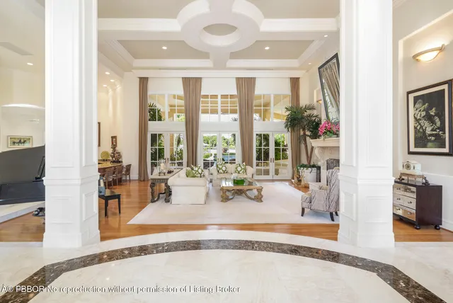 a living room with furniture a potted plant and a large window