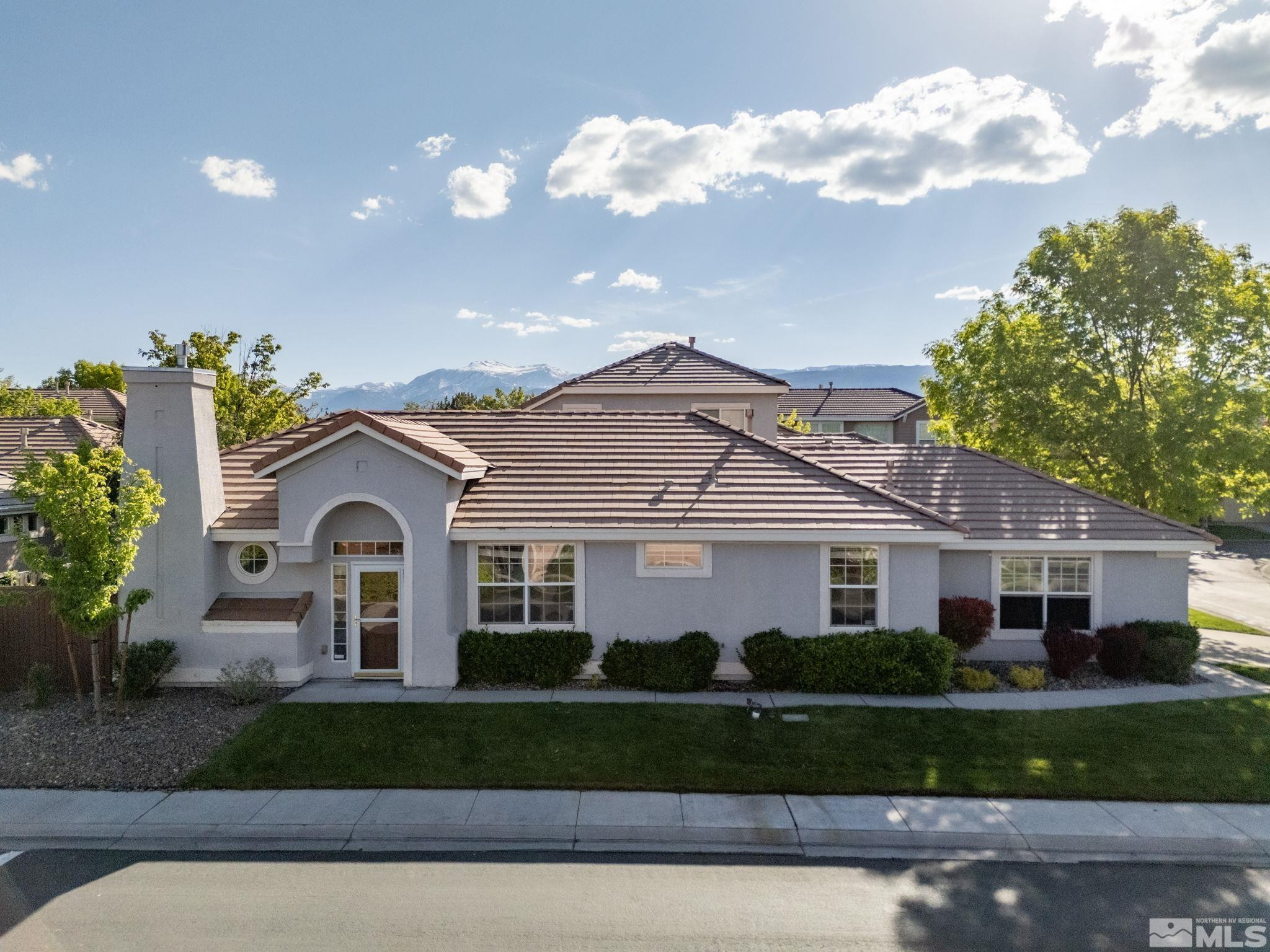 9653 Truckee Meadows Place Reno, NV 89521 - Photo 1 of 22 a front view of a house with a garden