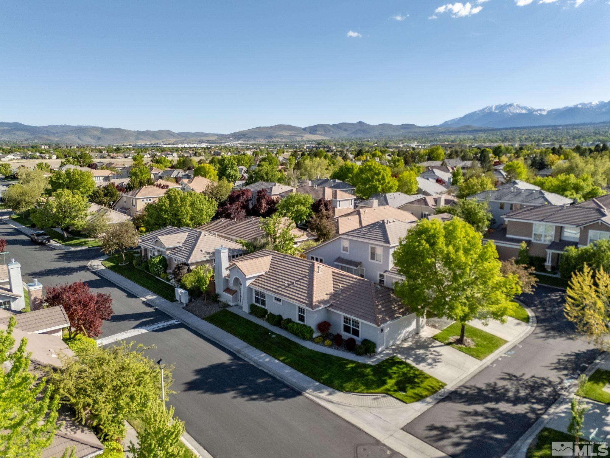 9653 Truckee Meadows Place Reno, NV 89521 - Photo 4 of 22 an aerial view of a city with lots of residential buildings and mountain view in back