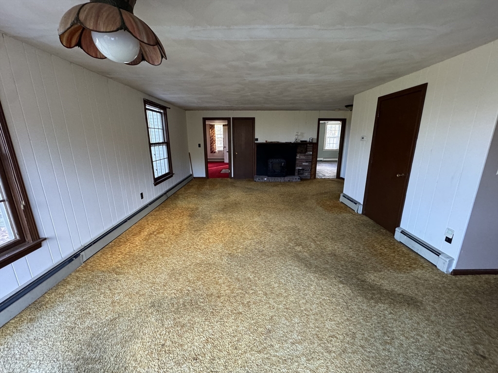 56 Barre Road Oakham, MA 01068 - Photo 7 of 36 a view of an empty room with a fireplace and window