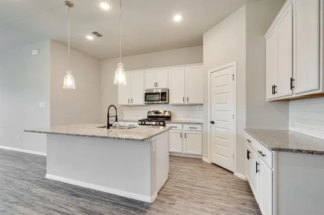 a kitchen with stainless steel appliances granite countertop a sink stove and refrigerator
