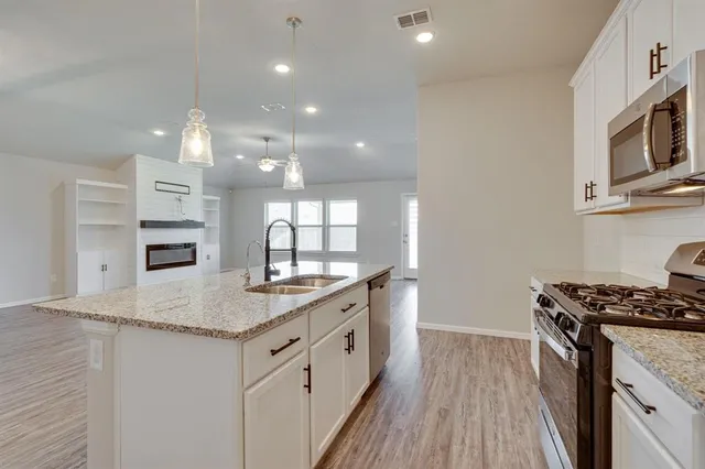a kitchen with stainless steel appliances granite countertop a stove and a sink