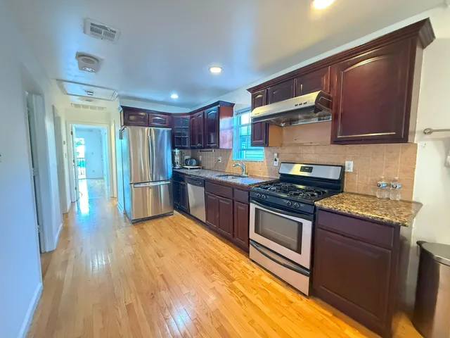 a kitchen with stainless steel appliances granite countertop a stove a sink and a refrigerator