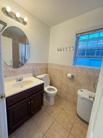 a bathroom with a toilet sink and mirror