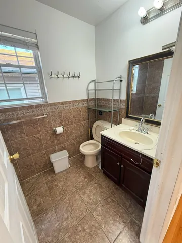 a bathroom with a double vanity sink toilet and a mirror
