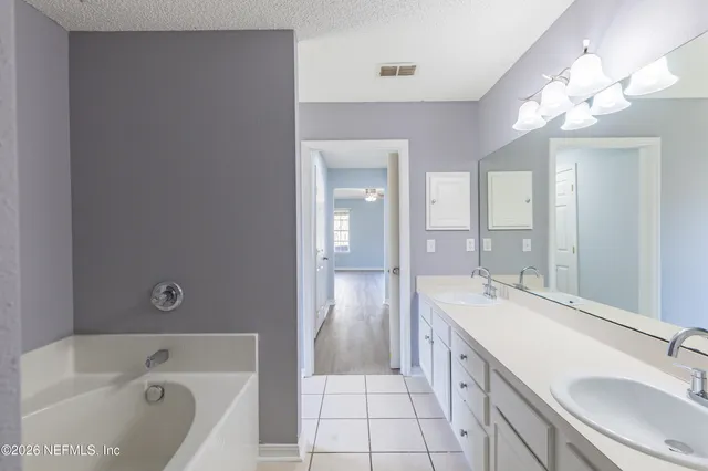 a spacious bathroom with a bathtub shower sink double and mirror