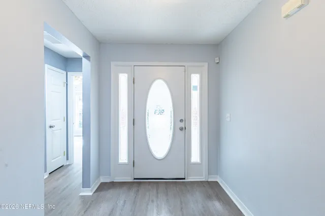 a view of an entryway with wooden floor and mirror