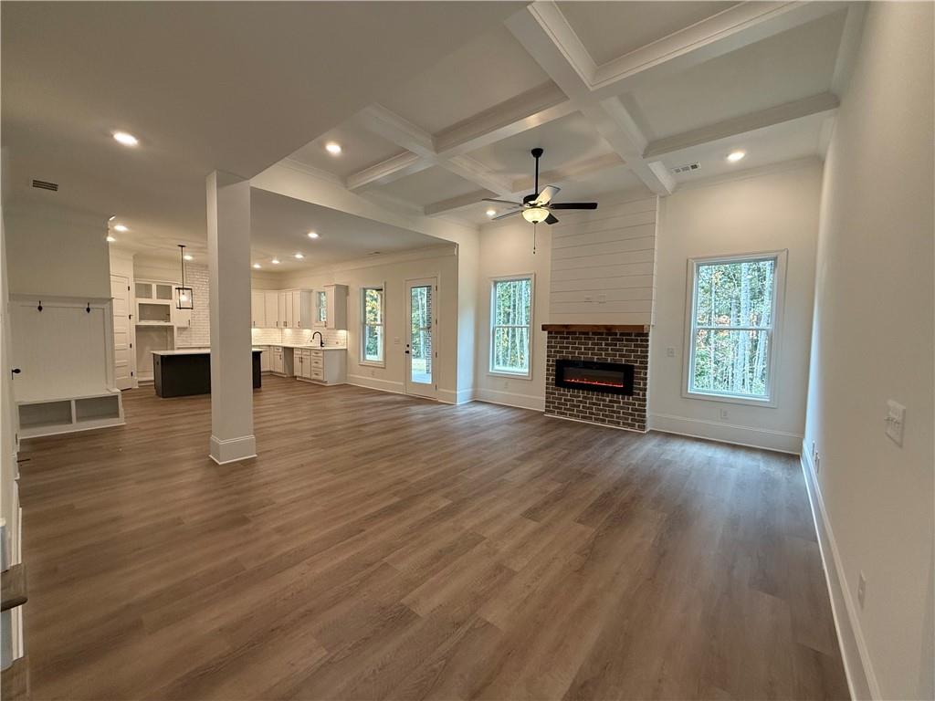 3229 Traditions Way Jefferson, GA 30549 - Photo 9 of 43 an empty room with wooden floor fireplace and windows