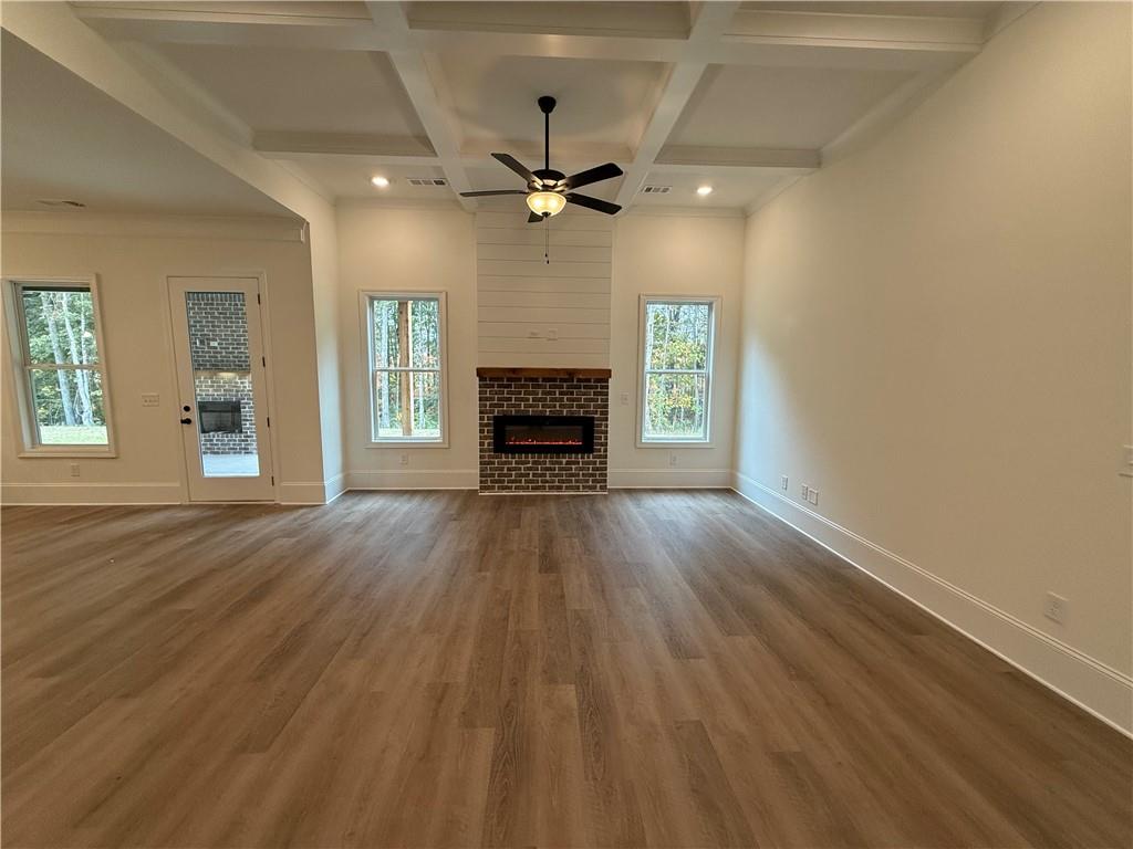 3229 Traditions Way Jefferson, GA 30549 - Photo 10 of 43 wooden floor fireplace and windows in an empty room