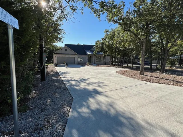 a backyard of a house with large trees and outdoor seating
