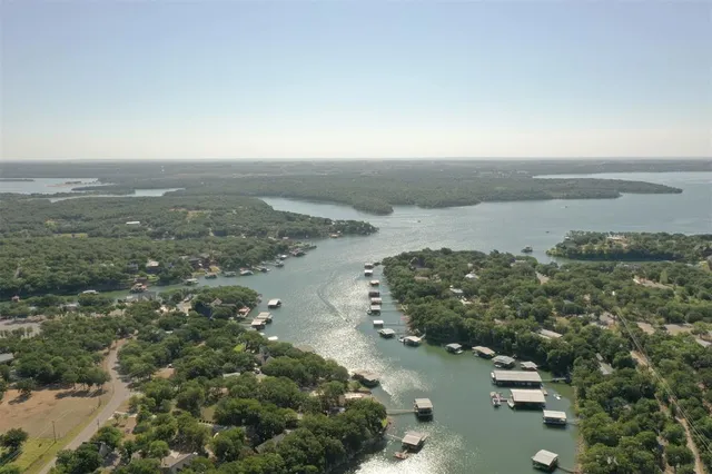 a view of a backyard with table and chairs potted plants and a large tree