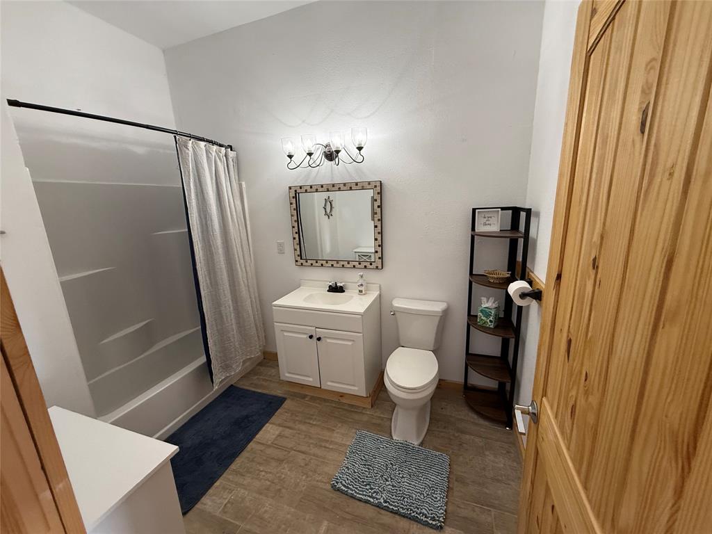 8072 Hells Gate Loop Strawn, TX 76475 - Photo 12 of 16 a bathroom with a sink a toilet a mirror and shower