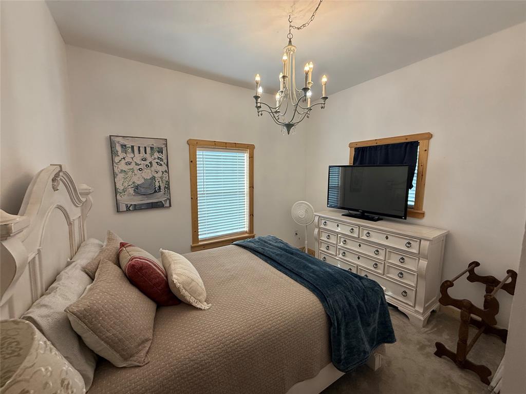 8072 Hells Gate Loop Strawn, TX 76475 - Photo 13 of 16 a bedroom with a bed and a flat screen tv