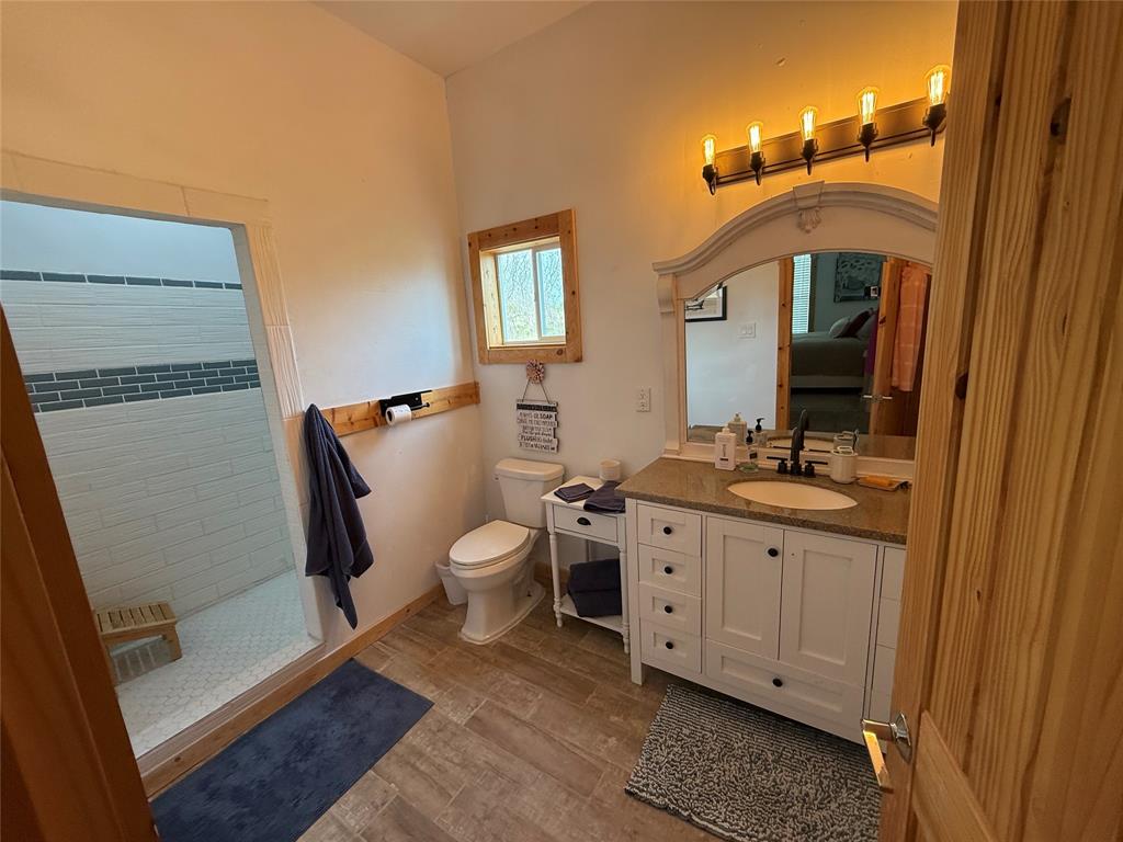 8072 Hells Gate Loop Strawn, TX 76475 - Photo 14 of 16 a spacious bathroom with a double vanity sink a mirror and a toilet