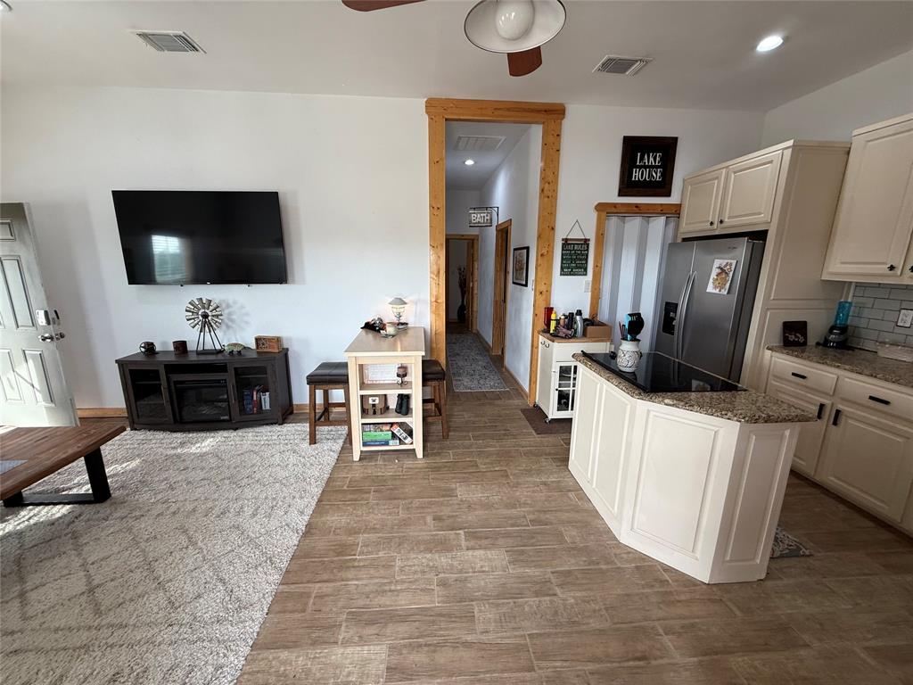 8072 Hells Gate Loop Strawn, TX 76475 - Photo 9 of 16 a living room with furniture a flat screen tv and kitchen view