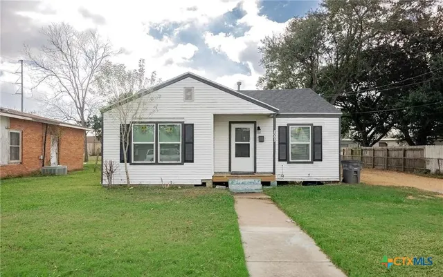 a front view of a house with a garden and yard