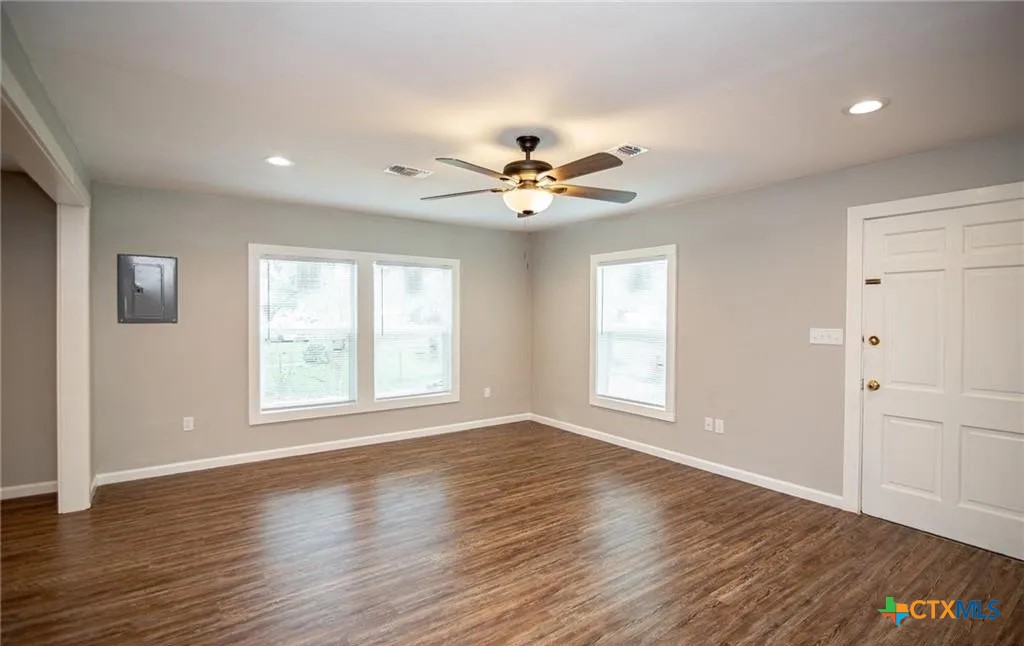 2003 Woodlawn Street Victoria, TX 77901 - Photo 2 of 35 an empty room with wooden floor and windows