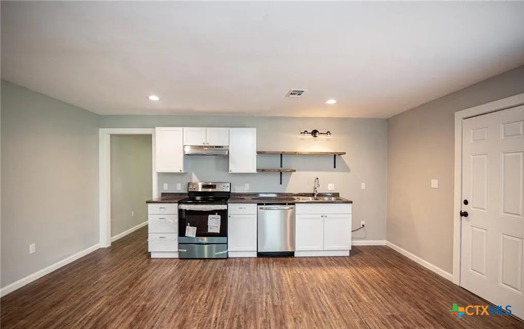 2003 Woodlawn Street Victoria, TX 77901 - Photo 5 of 35 a kitchen with stainless steel appliances a sink and wooden floor