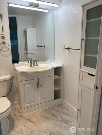 a bathroom with a sink toilet and mirror