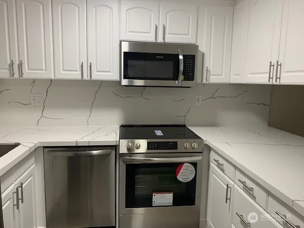 a kitchen with microwave cabinets and a stove top oven