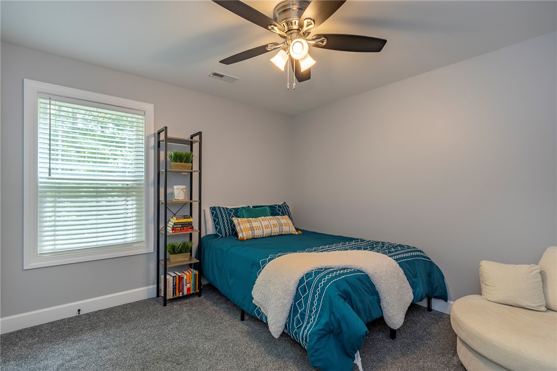 3080 McGee Road Iva, SC 29655 - Photo 19 of 49 A well-lit room showcasing a window with blinds and plush carpeting underfoot.
