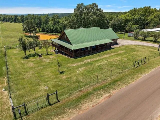 a view of a swimming pool with a patio and a yard