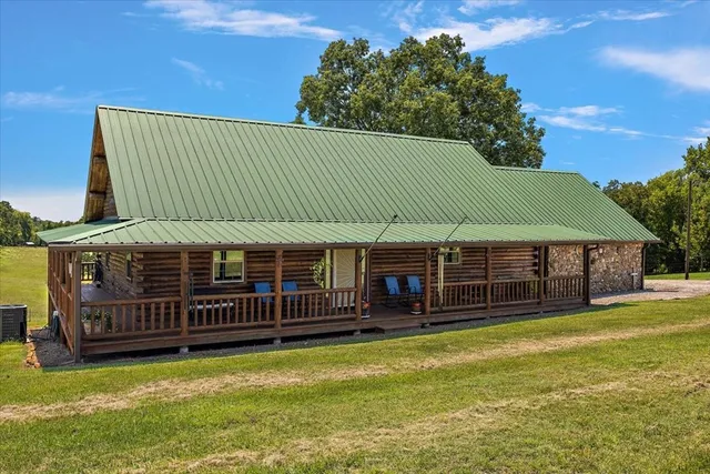 a view of a house with a backyard and a wooden deck