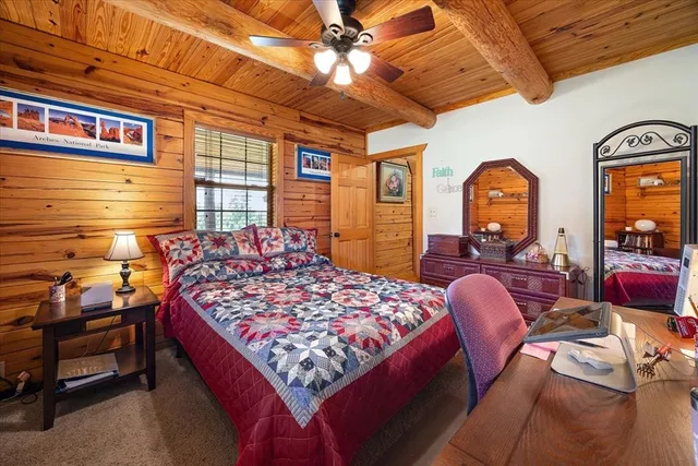 a bedroom with a bed dresser and a large window