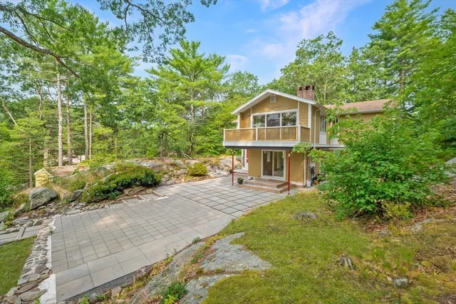 a view of a house with a yard and potted plants