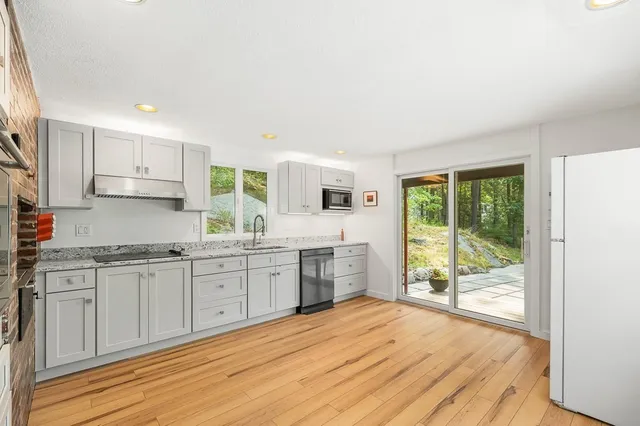 a kitchen with granite countertop a stove top oven sink and cabinets